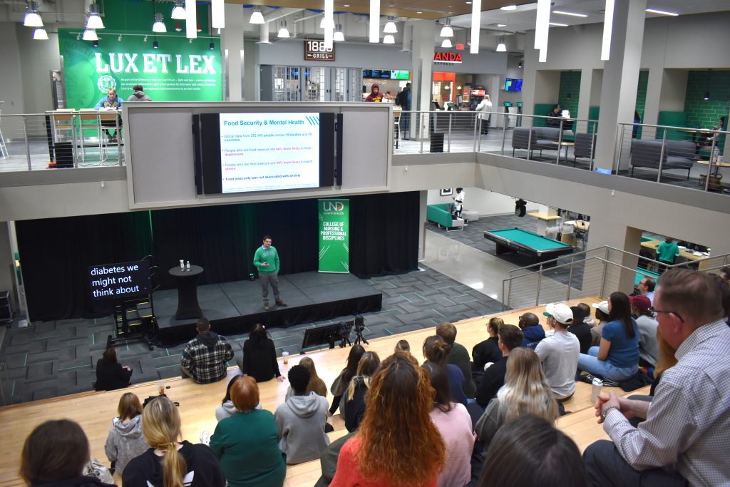 Presenter Dr. Nathaniel Johnson stands on a stage