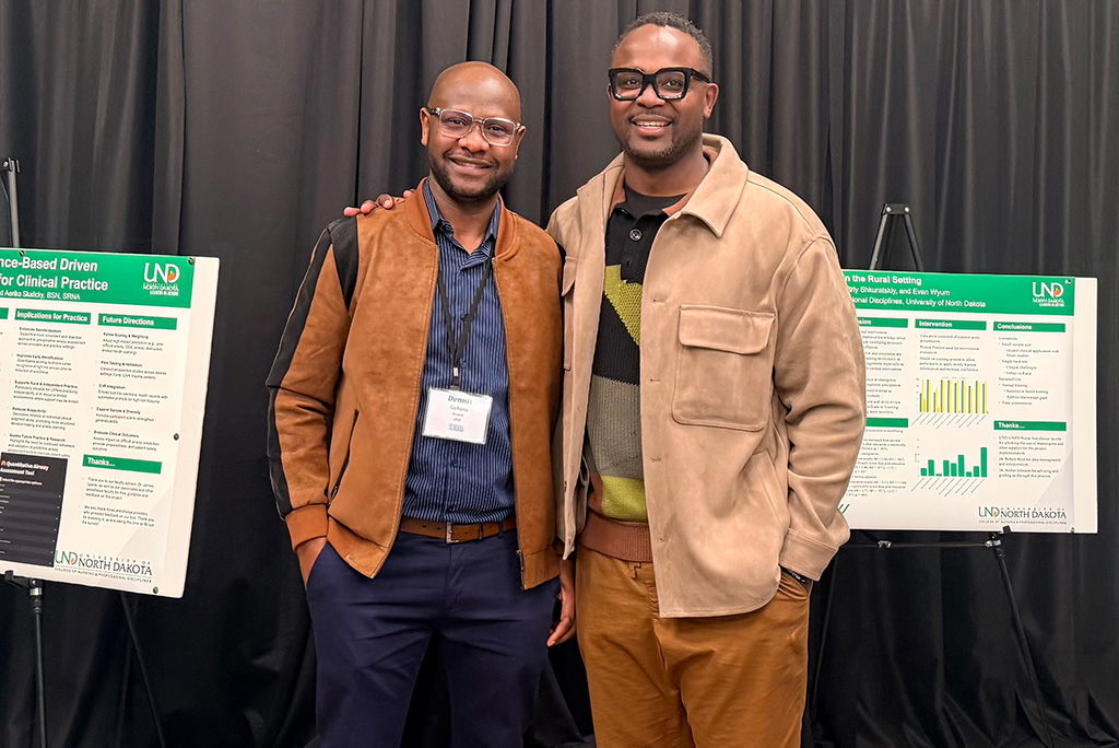 Deniis Gichana and Kevin Ogutu pose for a picture after reuniting at a conference