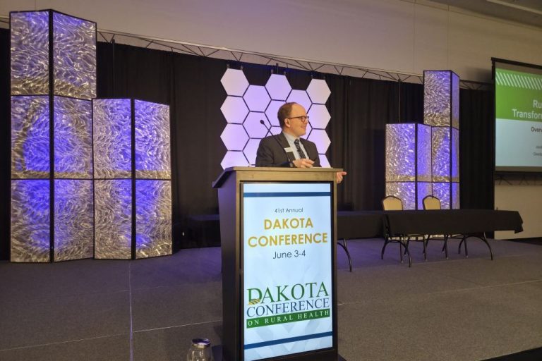 Jacob Warren, director of the UND Center for Rural Health, delivers the keynote address on stage.