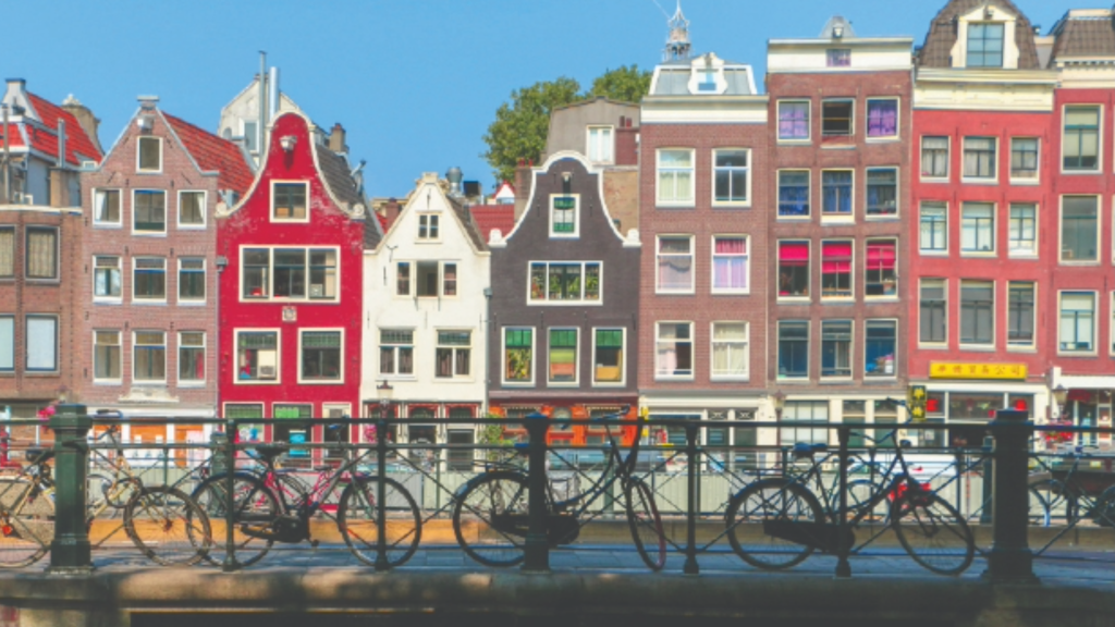Colorful houses line a canal in Amsterdam.