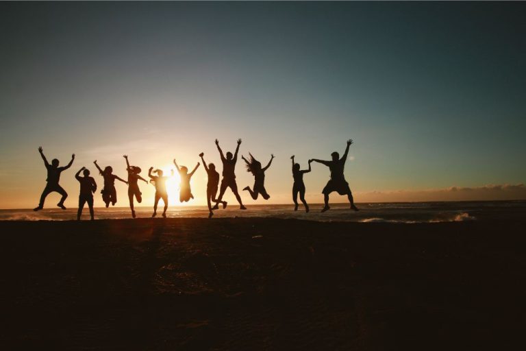 Silhouettes of people jumping together as if celebrating