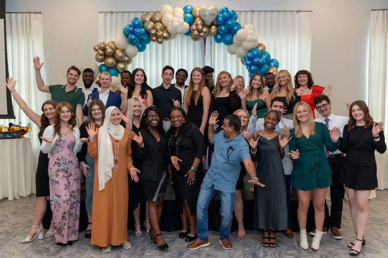 Interns pose for group photo at graduation ceremony