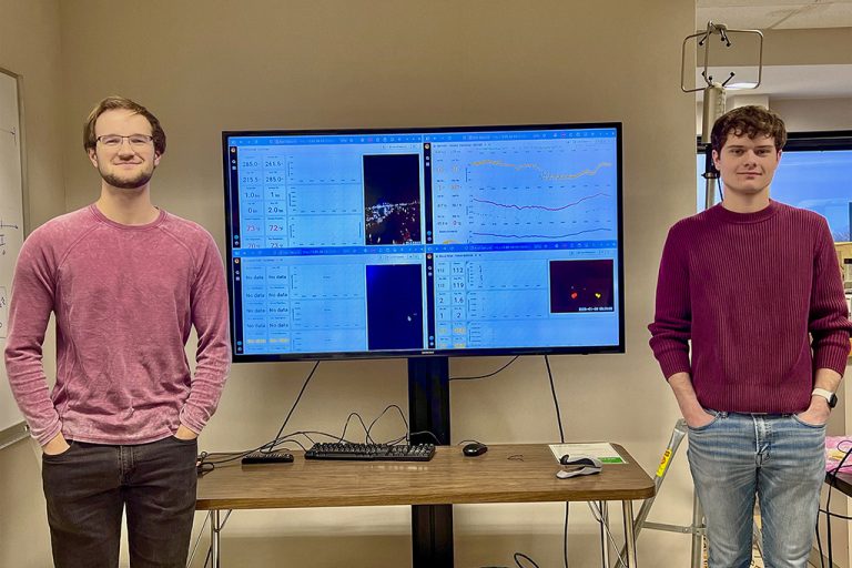 Conrad Slad (left) and Bryce Rickbeil (right) set up rooftop meteorological sensors on a tripod at Clifford Hall and process the resulting data streams, using live displays to visualize observations and quality-check measurements