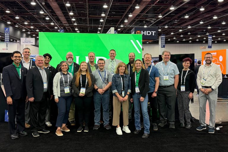 UND representatives at AUVSI conference gather for group photo in front of UND booth.