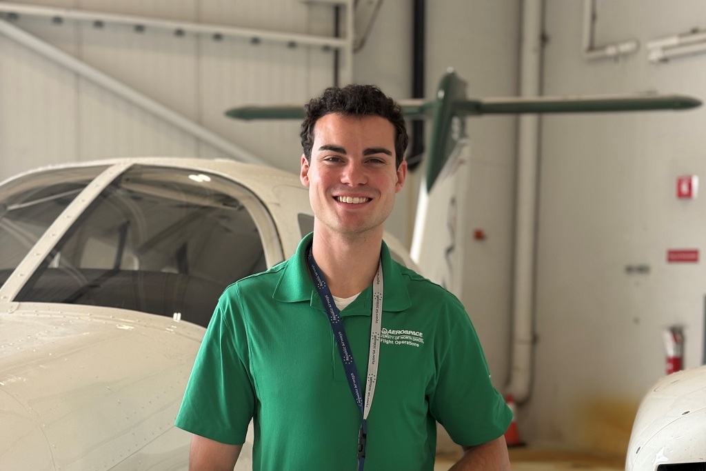 UND flight instructor stands by a UND aircraft inside a hangar