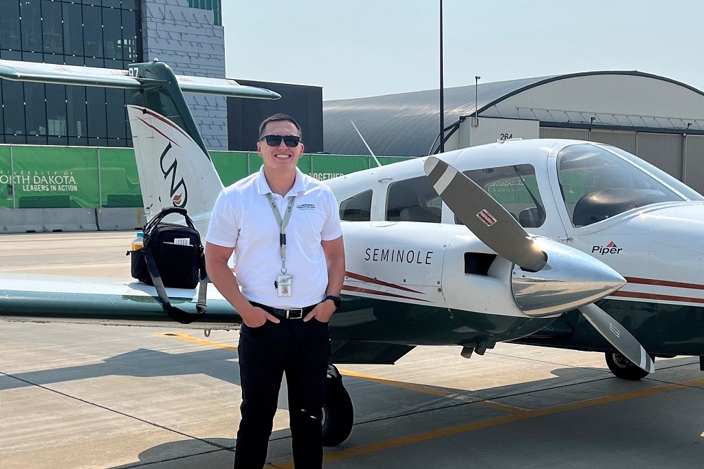 Man standing beside UND aircraft at Grand Forks International Airport in Grand Forks, N.D.
