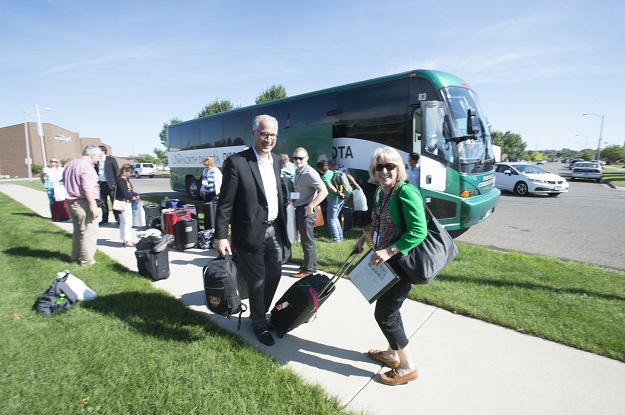 President Mark and First Lady Debbie Kennedy pick up their gear at one of the stops on the New Faculty and Administrators Bus Tour.