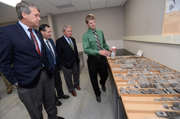 UND Ph.D. student Spencer Wheeling (right) shows core samples to North Dakota Industrial Commissioner members: Attorney General Wayne Stenehjem, Agriculture Commissioner Doug Goehring and North Dakota Gov. Jack Dalrymple. Photo by Jackie Lorentz.