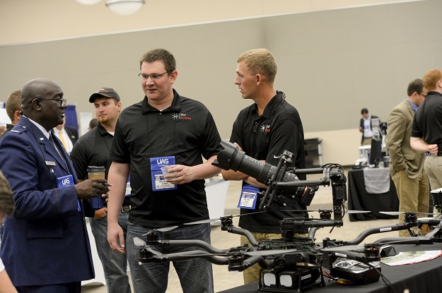 Matt Dunlevy (center), CEO/president of SkySkopes, a UAS business that has it roots at UND, and Cory Vinger (right) talk with U.S. Air Force Col. Paul Young (left) from Lackland (Texas) Air Force Base. Young is looking at ways to use UAS to deliver medical supplies in military search-and-rescue operations. Photo by Jackie Lorentz.