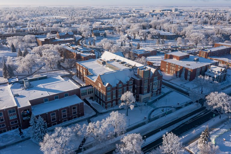Aerial view of Nistler College and surrounding campus buildings, under cover of snow