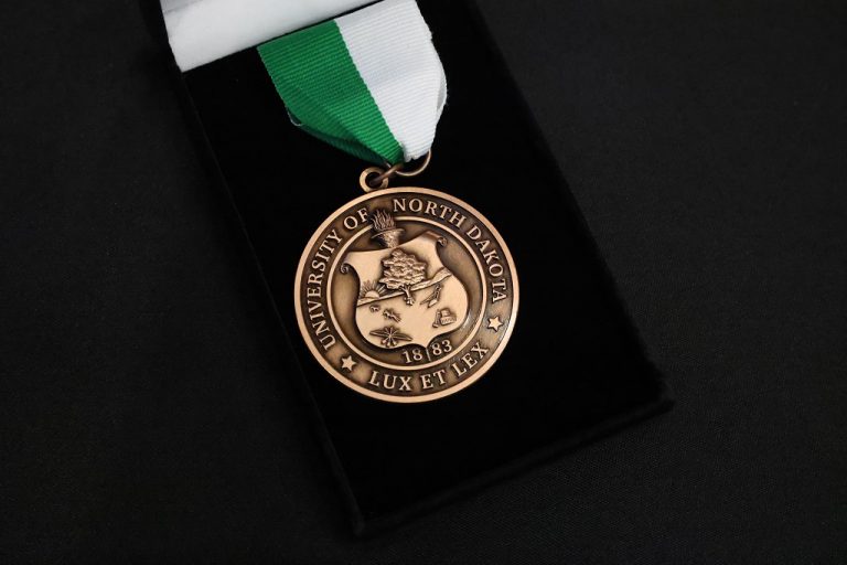 Close-up of UND medal featuring the university's seal and motto