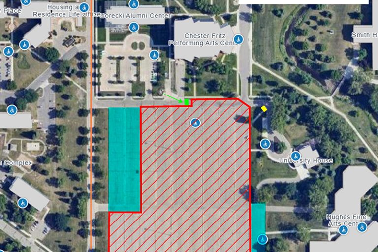 Map view of CFPAC parking lot showing available parking in blue, closed area of lot in red hashes and blocked entries with red lines. Orange arrows indicate truck traffic.