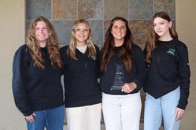 Alex Skime holding award alongside members of student team