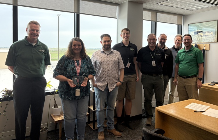 LoAnn Stadstad holding award plaque alongside colleagues