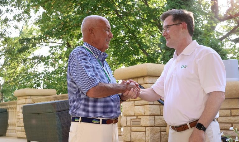 B. John Barry (left) shakes hands with UND President Andy Armacost after receiving the President’s Medal from Armacost, Aug. 19, 2021. The President’s Medal is the highest honor that the president of the University can confer. UND Alumni Association & Foundation photo.