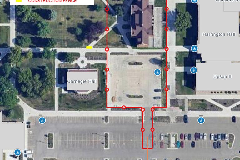 Map view of Babcock Hall site showing red boundary of construction fencing and parking lot closure, including yellow markers showing sidewalk blocks and orange arrows showing direction of traffic near parking lot