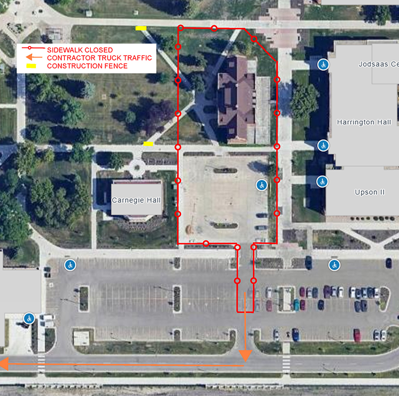 Map view of Babcock Hall site showing red boundary of construction fencing and parking lot closure, including yellow markers showing sidewalk blocks and orange arrows showing direction of traffic near parking lot