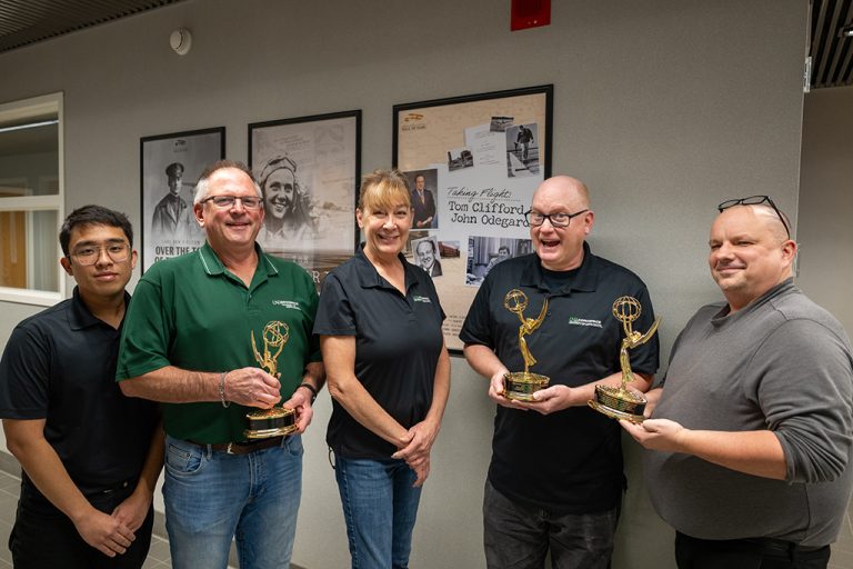 UND aerospace network staff holding three emmy trophies