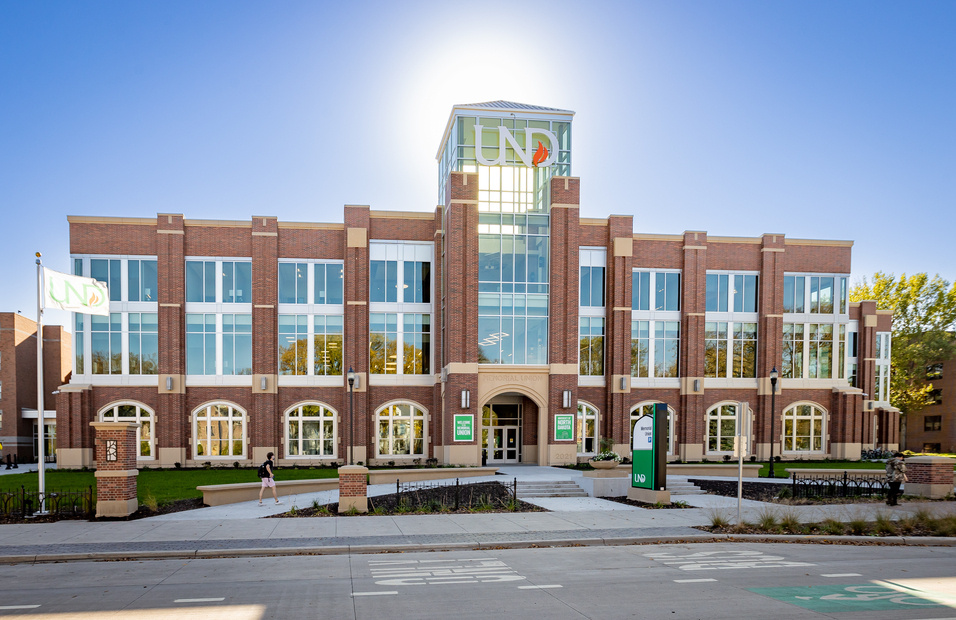 Exterior of Memorial Union with sun directly behind the top of the building, from University Avenue