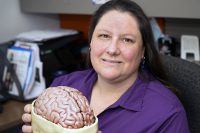 Rebecca Quinn holds  a model of a human brain in her office at the UND Center for Rural Health, part of the School of Medicine & Health Sciences. Quinn, a social worker who manages the North Dakota Brain Injury Network, is an advocate for the prevention of traumatic brain injuries. Photo by Jackie Lorentz.