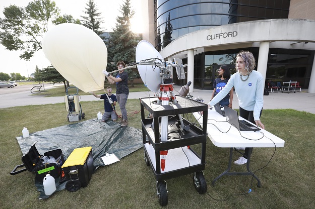 Denise Buckner, (right), prepares for a balloon test launch with Lance Wilson (kneeling), Peter Henson and Anamika. Ten team members will travel to Idaho capture the eclipse. 