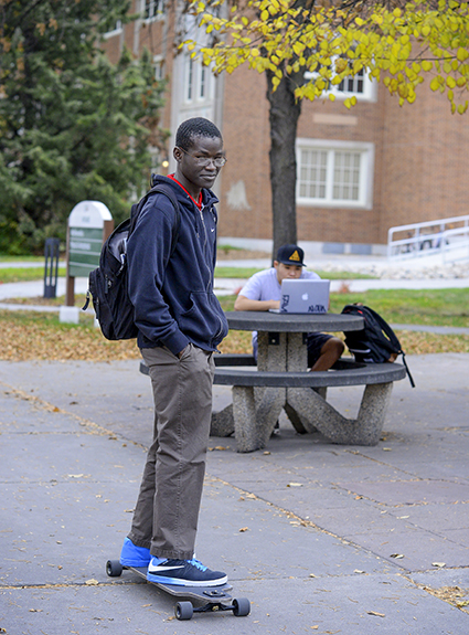 UND student Vincent Biyogo, originally from Kenya, enjoys riding his long board on campus in early fall. Photo by Jackie Lorentz.