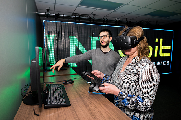 Stefano Tenca with Qbit Technologies, Palo Alto, Calif., demonstrates the virtual reality capabilities of the Hess Virtual Reality Lab to Joan Jensen, Solberg Success Center. Photo by Tyler Ingham.