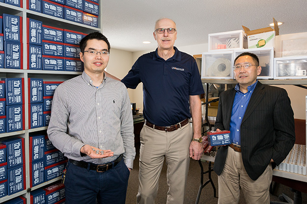 Xiaodong Hou and Mike Mann, both with the UND Institute for Energy Studies, pose with Yong Hu, co-founder of Clean Republic in Grand Forks. The company uses UND-developed technology to manufacture batteries that last longer under extreme conditions and are used in e-bicycles, fish finders, ice augers and other outdoor equipment. Photo by Tyler Ingham/UND Today.