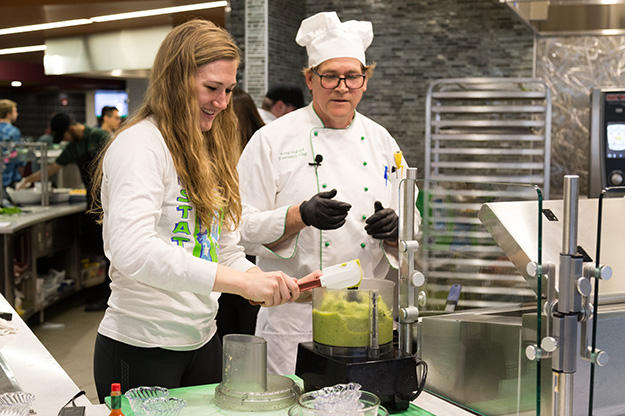 Executive chef Greg Gefroh demonstrates how to make easy guacamole with a student athlete's help.