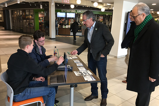 Governor Doug Burgum takes a moment after lunch at UND’s Wilkerson Commons to pick up some raffle tickets from Alpha Sigma Phi’s Carson Hein (far left) and Mark Frahm. Photo by Kaylee Cusack/UND Today.