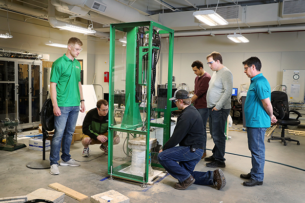 UND Drillbotics team member Thomas Nelson says the drill may penetrate limestone with ease, but granite is a challenge they’re still addressing. The team made concrete slabs and also uses rock samples provided by the Laird Core & Sample Library on campus. Photo by Shawna Schill/UND Today.