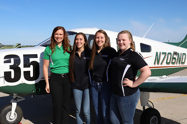 From left to right: UND Assistant Chief Flight Instructor and coach Erin Roesler, Monique McAnnally, Dakotah Osborn, and Jenna Annable stand in front of ‘Evelyn’, the Piper Archer aircraft they will use in 2018’s Air Race Classic. Missing from the group photo is Emily Hartley, the team’s ground coordinator, as she was completing her certification as a UND flight instructor. Photo by Connor Murphy/UND Today.