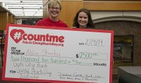 Abbie Sheehy, a freshman from Waysata, Minn., hold up her oversized prize check with UND Alumni Association & Foundation CEO DeAnna Carlson Zink. Sheehy was one of the first students to have her name drawn by random for a Giving Hearts Day scholarship.
