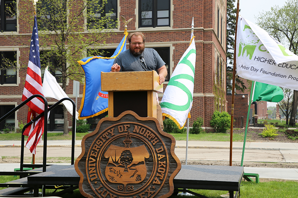 man speaking at podium outdoors