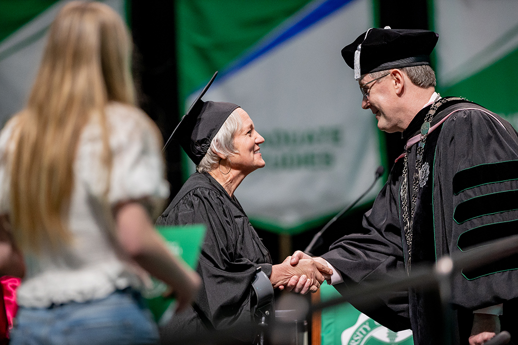 Graduate shaking hands with President Armacost