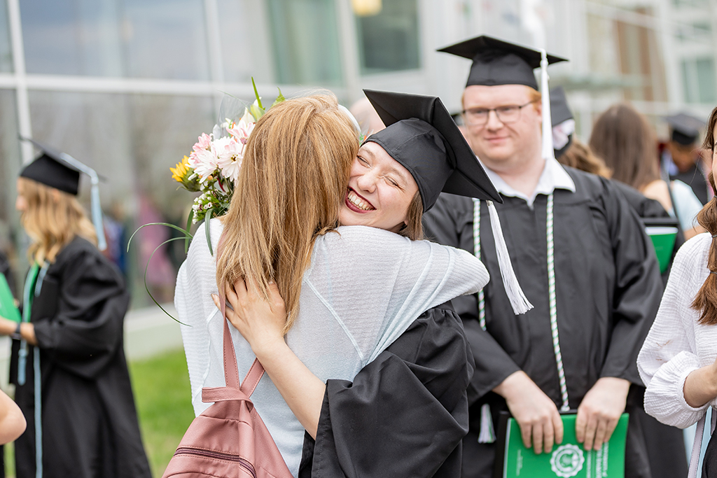 Graduate hugging family