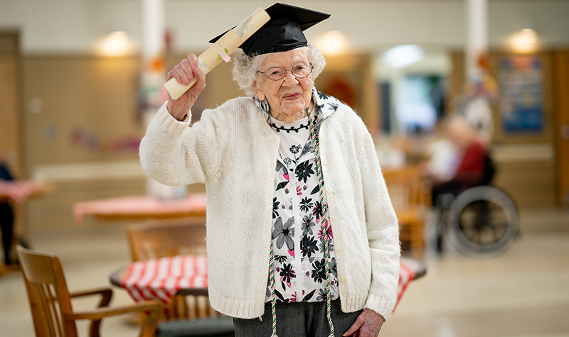 Iris Westman wearing graduate cap, holding scroll