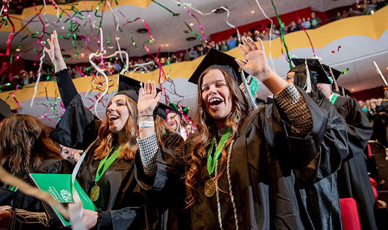 Students at commencement with confetti falling