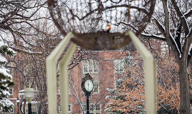 View of clock in front of Twamley Hall under eternal flame