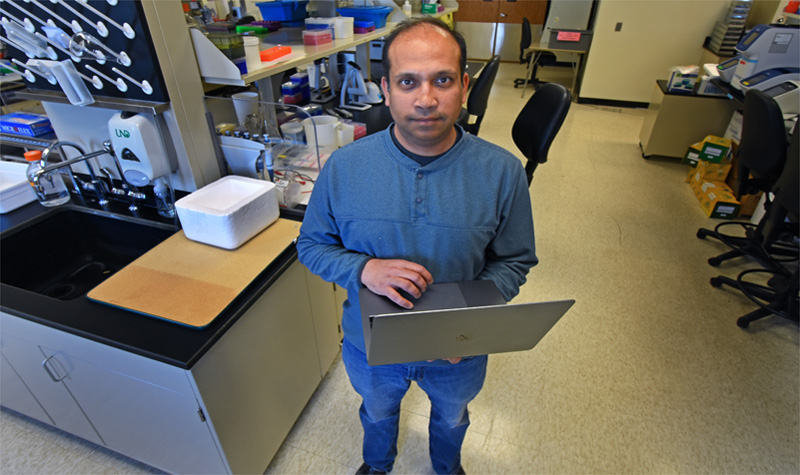 Manu Manu holding open laptop