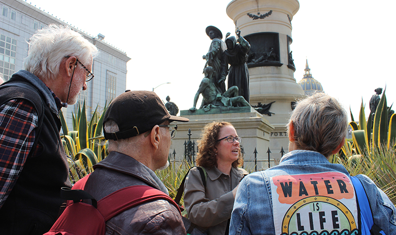 Cynthia Prescott guides tour in front of statues