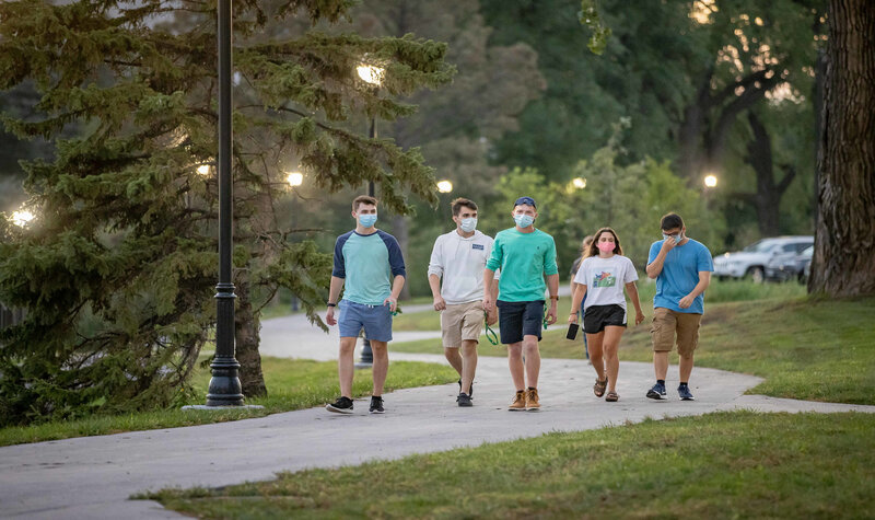 Students walking on campus wearing masks