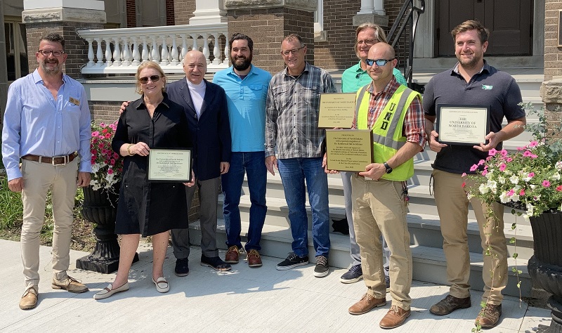 Officials involved in development of Gershman Graduate Center holding plaques