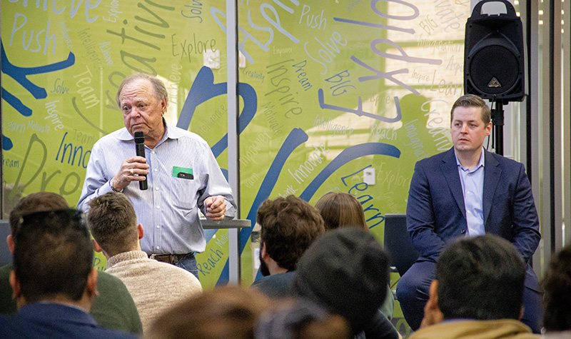 Harold Hamm holding microphone as Brian Tande looks on