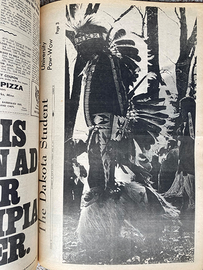 Newspaper clipping with large photo of person in tribal clothing