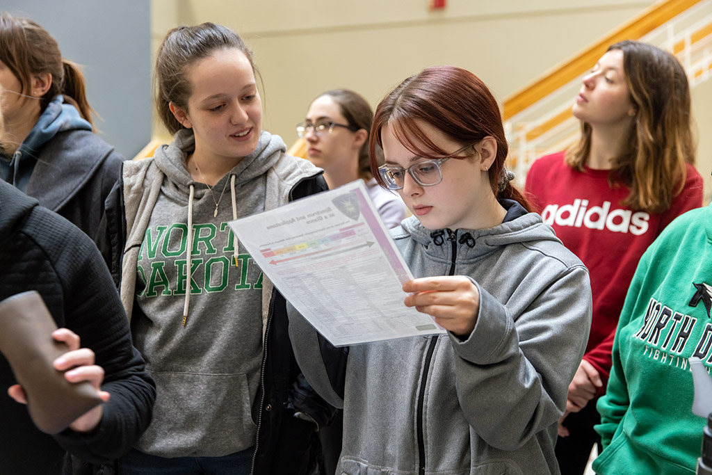 forensic science students look over guide on color goggled