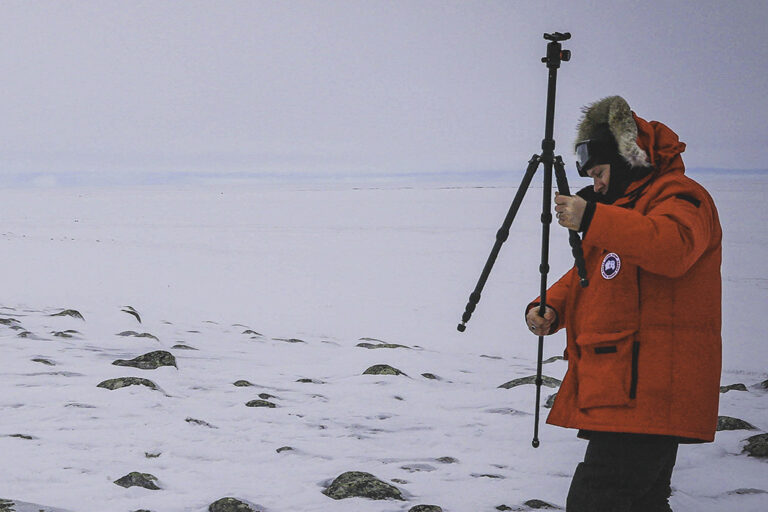 Timothy Pasch setting up tripod in the field