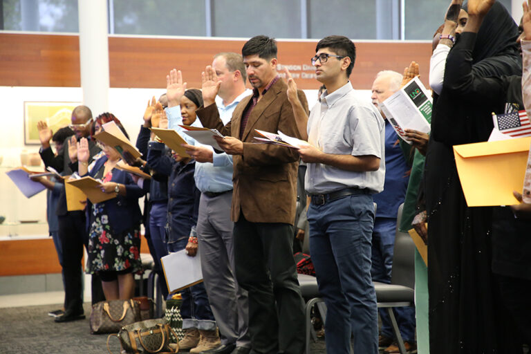 New citizens raise hands to take oath