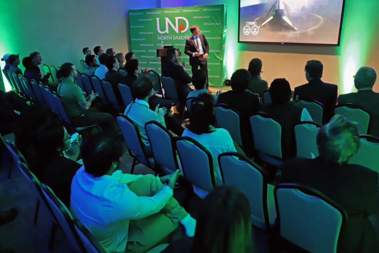 Audience at presentation watches video