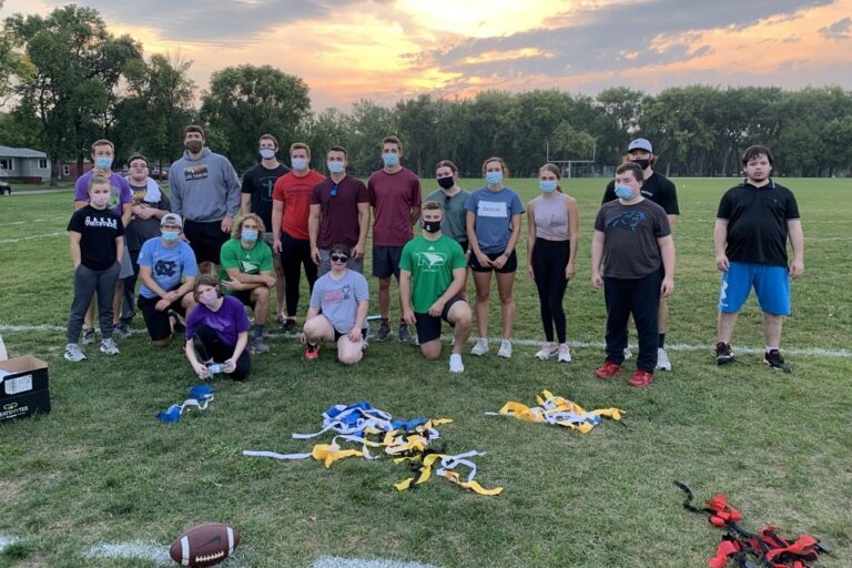 Students on field with flag football equipment